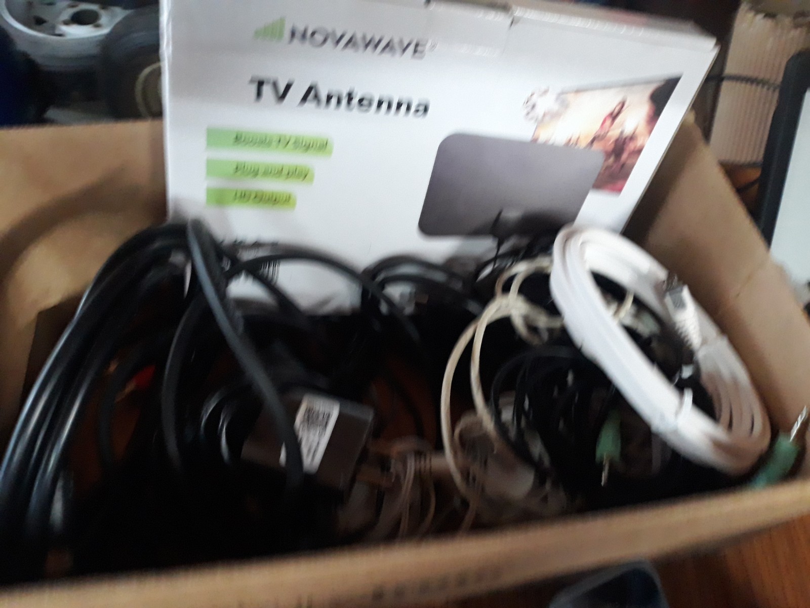 Table Full Of Miscellaneous Electronics Phones Chargers DVD Player Selfie Stick